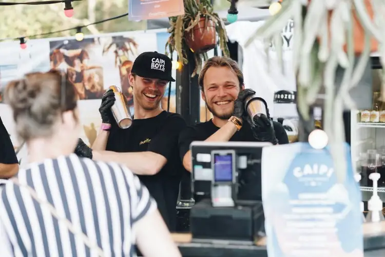 Twee bartenders die lachend achter de bar staan