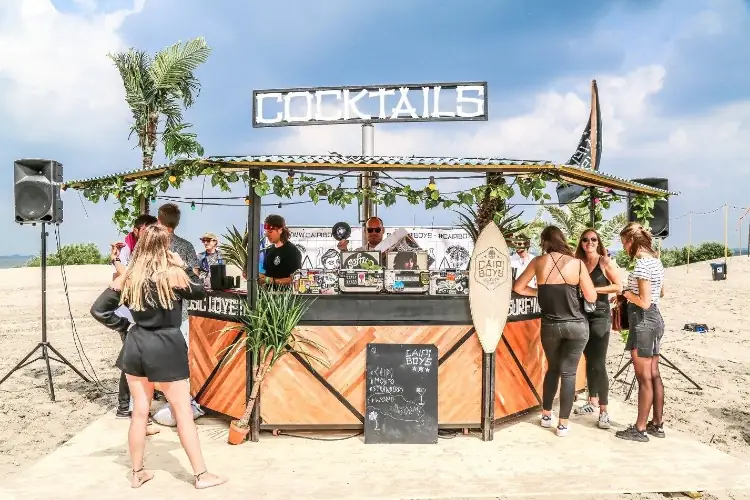 Een gast met een cocktail in de hand bij een festivalbar