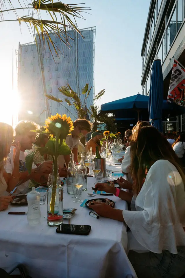 Lange gedekte tafel op het terras in de avondzon met zonnebloemen