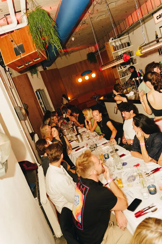 Lange tafel vol gasten binnen in het café